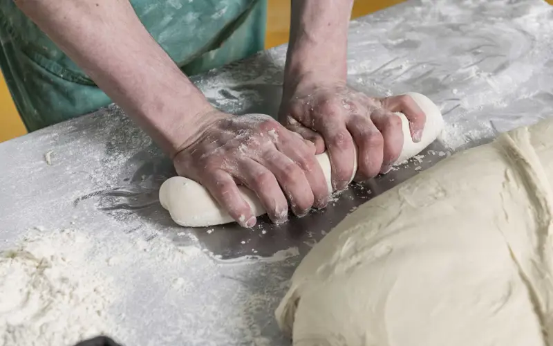 Baker preparing dough at Maclean's Highland Bakery, Forres,