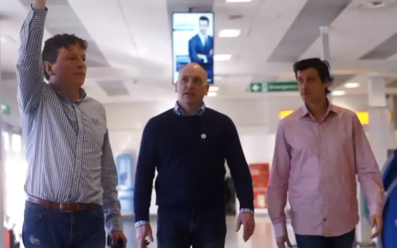 Three men walking in an airport lounge