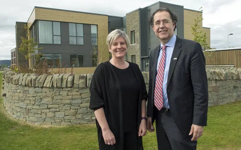 Lesley Patience and Dr Cornelius Glissman of CorporateHealth International standing outside Aurora House on Inverness Campus